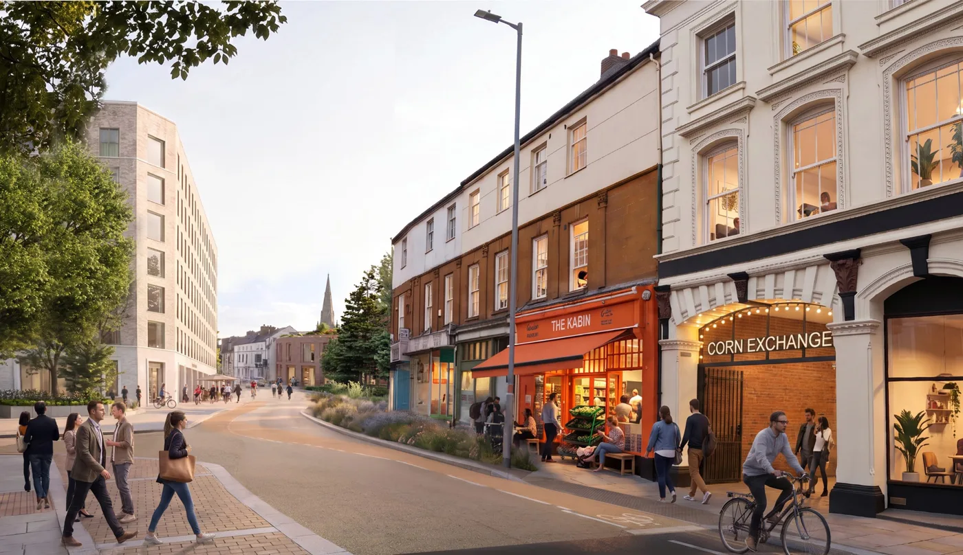 A computer-generated street view of Sheep Street in Northampton with the Corn Exchange frontage reopened, a cafe next door, a cycle lane and planting, and a tall new building in the distance